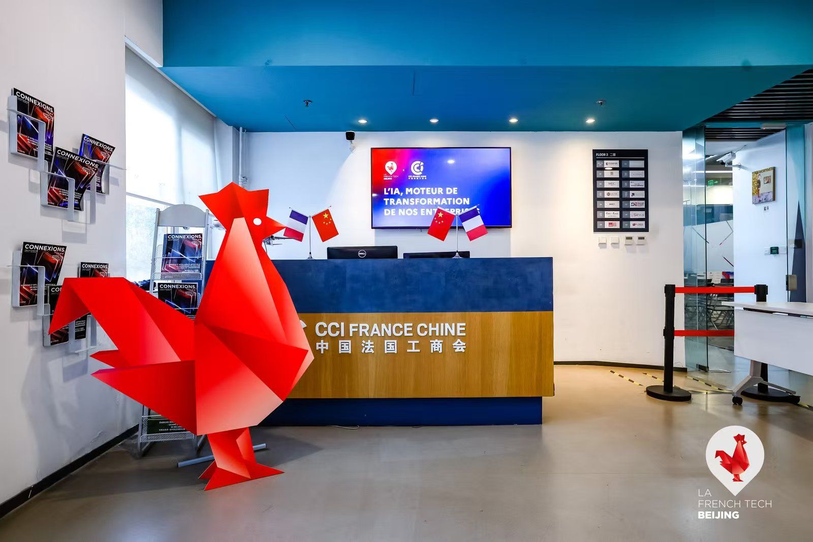 Accueil de la CCI France Chine avec le coq origami rouge et l'affiche de la soirée à l'écran